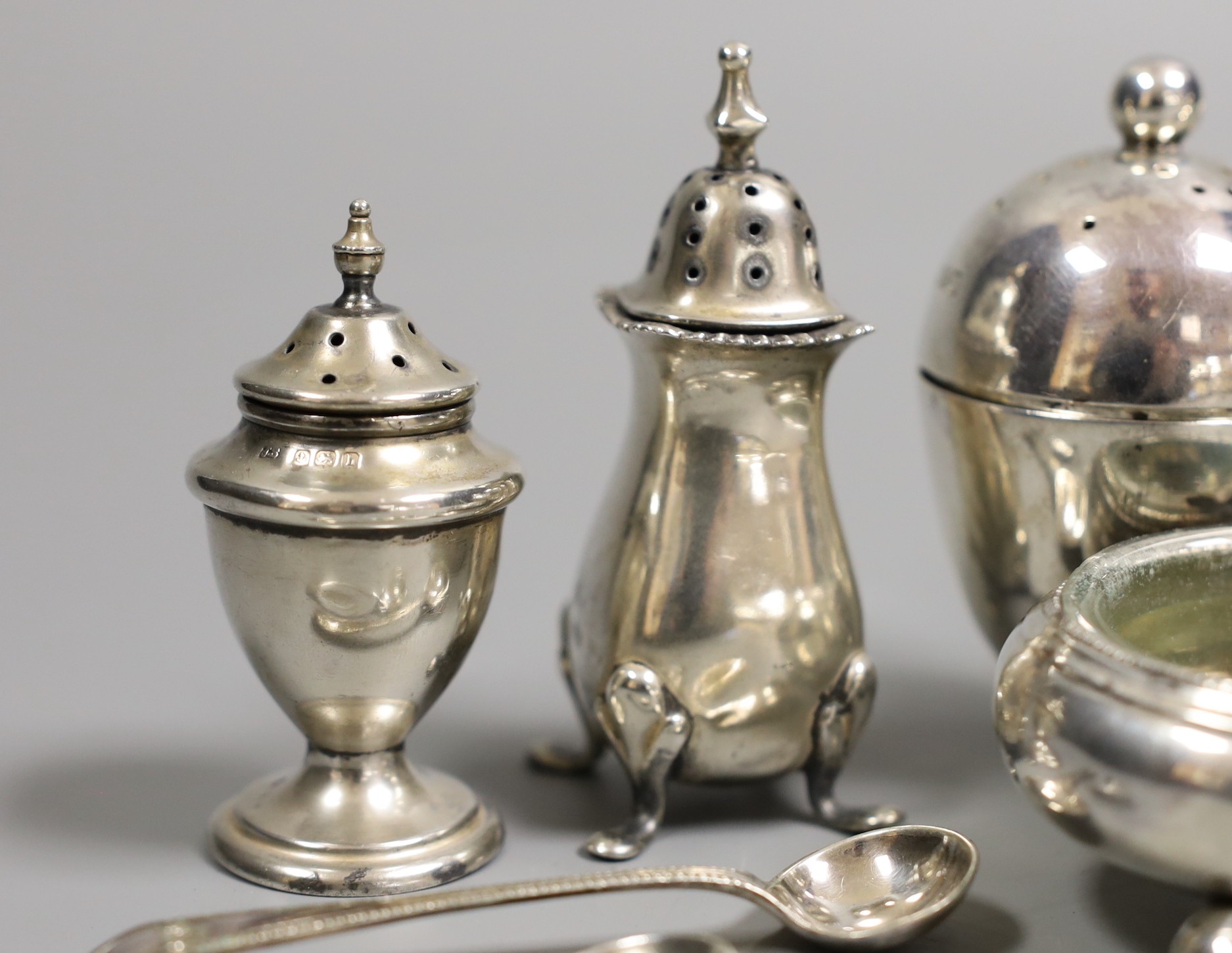 An Edwardian silver cruet stand, by Goldsmiths & Silversmiths, London, 1901, four other silver condiments and a set of six silver coffee spoons.